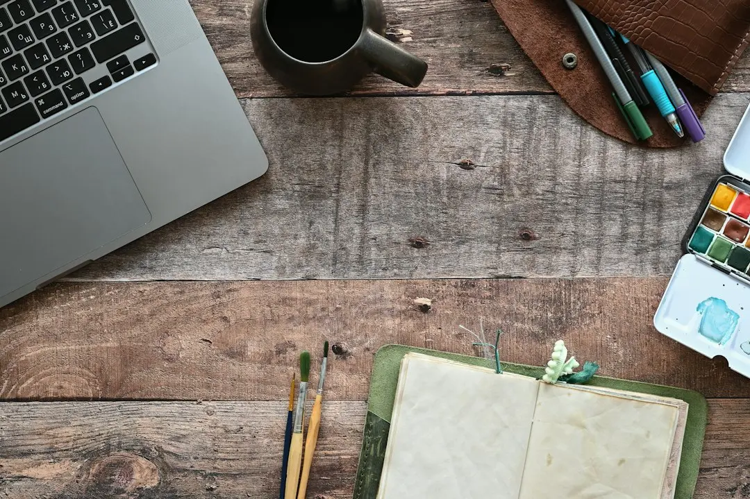 Top view of a rustic wooden desk with a laptop, a mug of coffee and an open notebook, ready for comparing IPTV services before choosing GaroxTV